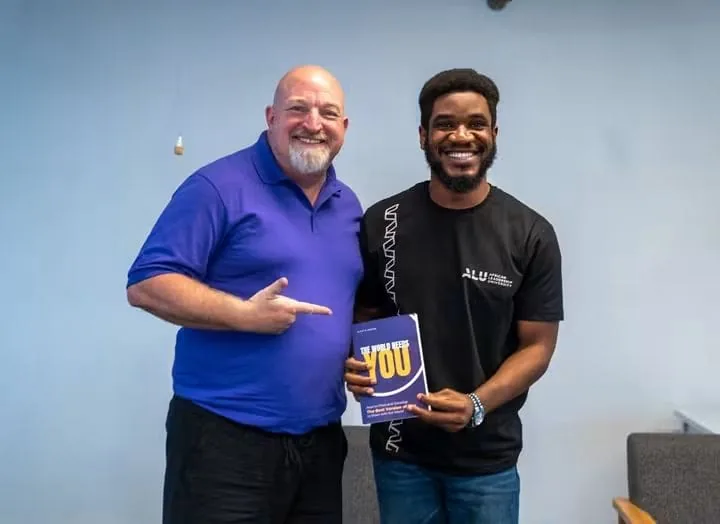 Paul Udah presenting a copy of his book, YOU