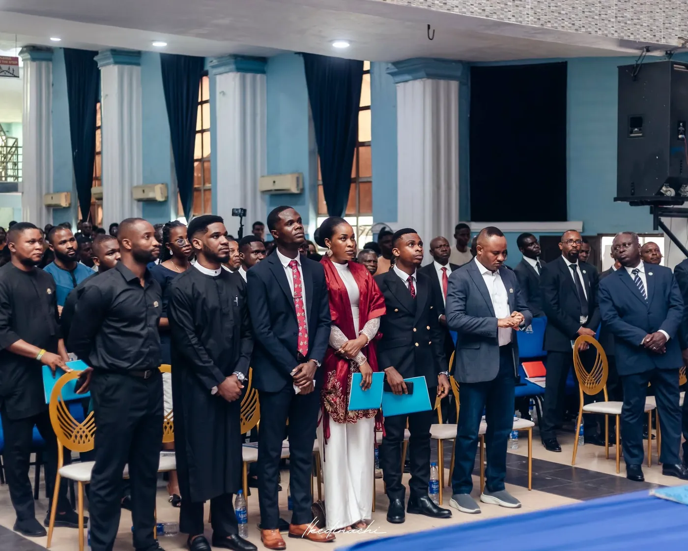 Paul Udah standing with guests during the conference