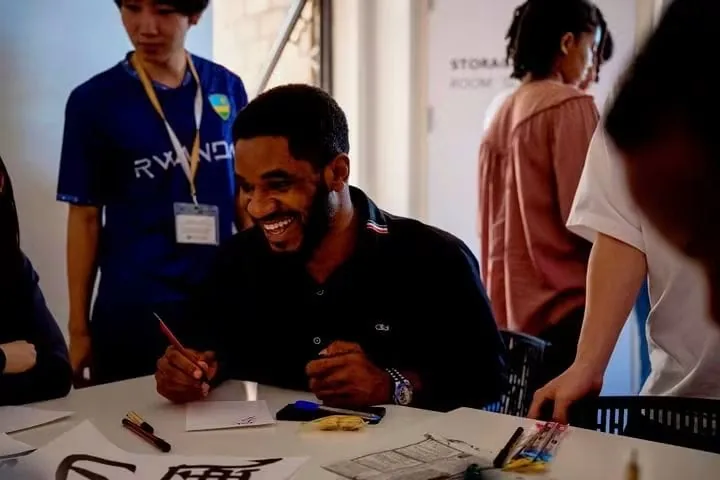 Paul Udah taking part in a calligraphy session in Rwanda